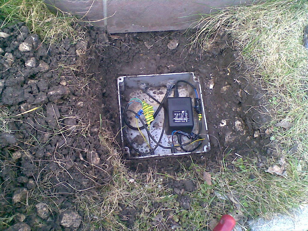 Csak kitartóan kell keresni. A képen egy szökőkút motorját és világítását tápláló, biztonsági törpesfeszültséget előállító tápegységét látjuk. Sokáig kerestük, hogy hol lehet, mire a medence fejénél óvatosan elkezdtünk ásni és megtaláltuk a föld alatt. Beküldő: Novák Ernő 